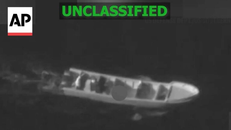 Night-vision image of a small boat with passengers on dark water; label UNCLASSIFIED at top and AP logo on left.