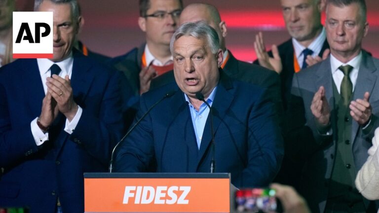 Politician speaks at a podium with an orange 'FIDESZ' banner, flanked by supporters clapping; AP logo overlay on the image
