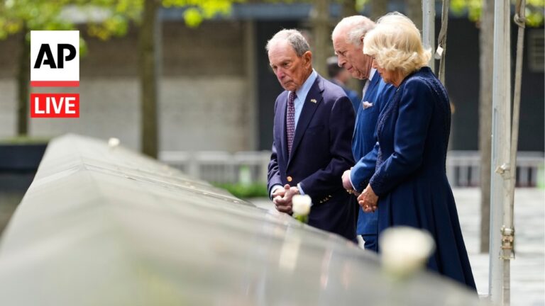 Three older adults in formal attire stand beside a glazed railing, looking down with solemn expressions; AP Live logo is visible on the left.