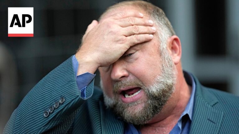 Distressed man in a blue shirt and striped blazer holds his forehead with one hand; AP logo in top-left corner.