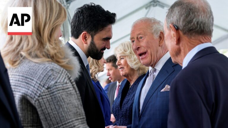 Group of professionally dressed adults chatting and shaking hands at a formal event; AP logo in the corner.