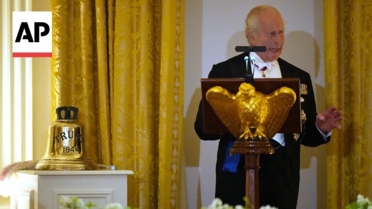 AP logo in the corner; gold bell labeled 'TRUMP 1944' on a pedestal beside a man at a lectern with an eagle emblem.
