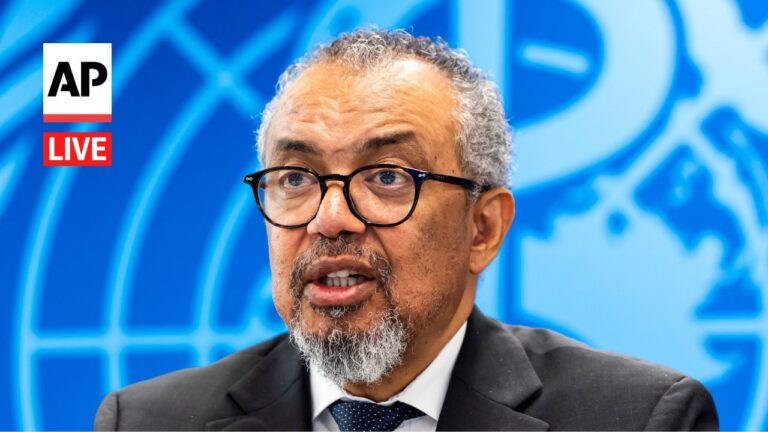 Man with glasses and a gray beard speaks during an AP Live interview with a blue world map backdrop and AP Live logo visible on the left.