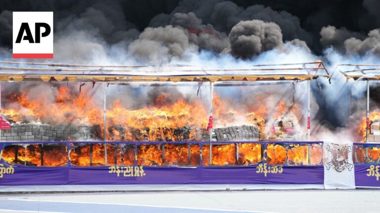 AP watermark in top-left; burning tires and large flames behind a barricade, with dark smoke rising—conveys a chaotic street protest scene.