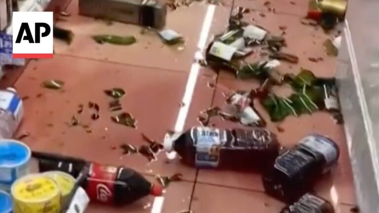 Store floor littered with spilled beverages, broken items, and debris; AP watermark in the corner.