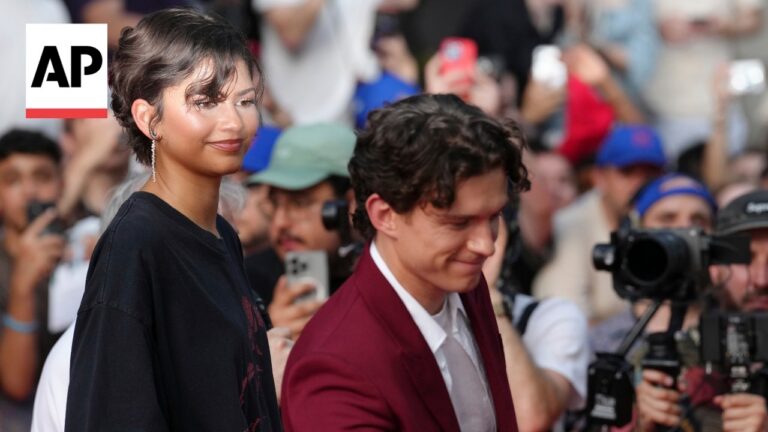 Two celebrities on a red carpet as photographers swarm, AP logo visible in the top-left corner.