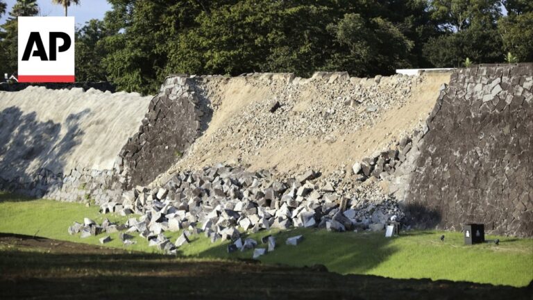 AP logo left; a stone retaining wall collapsed with rubble spilling onto a green lawn in front.