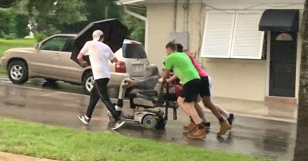 Four Young Men Help Stranded Elderly Woman in the Rain with Scooter.jpg