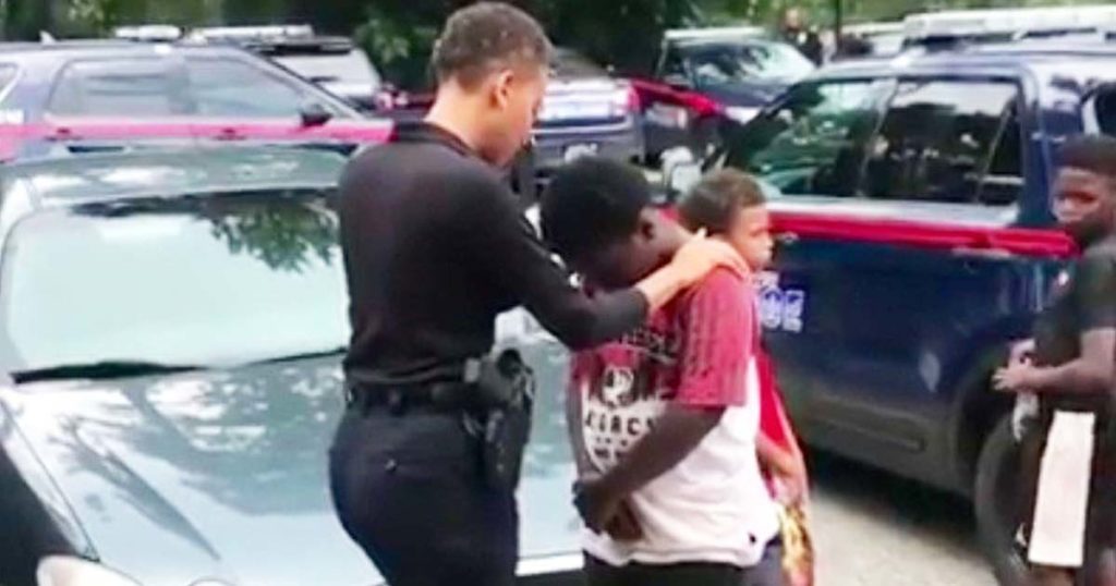 Officer Prays with Young Boy: A Moment of Compassion and Community Care.jpg
