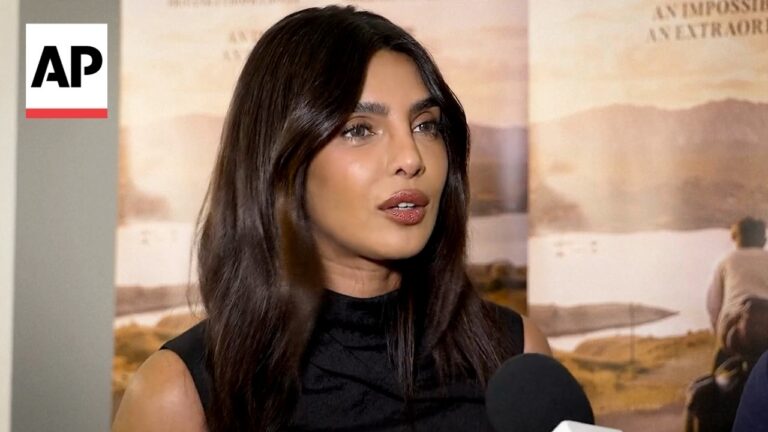 Woman being interviewed on camera, AP logo visible in the upper-left corner and a desert-themed backdrop behind her.