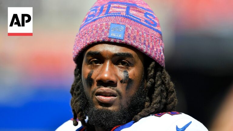 Close-up of a Buffalo Bills football player with black eye paint, wearing a pink knit cap; AP logo visible in the upper-left corner.
