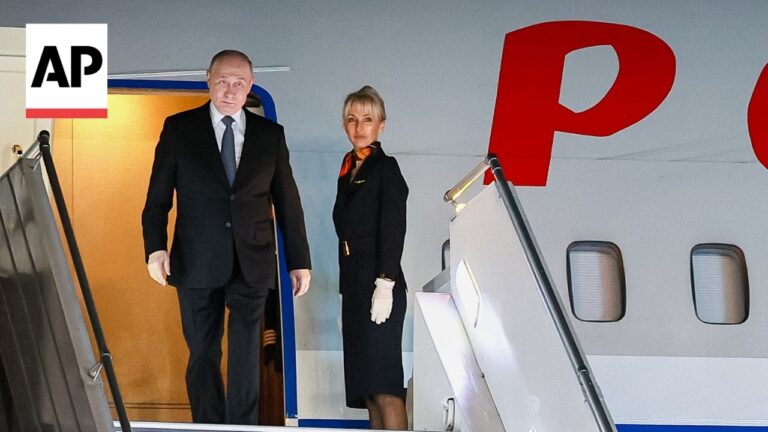 Two people in formal attire stand at the open door of a large airplane, AP logo visible.