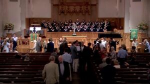 1789983761_maxresdefaultjpg - New Social Gospel Church interior with a large choir onstage as attendees mingle in the nave before a service.