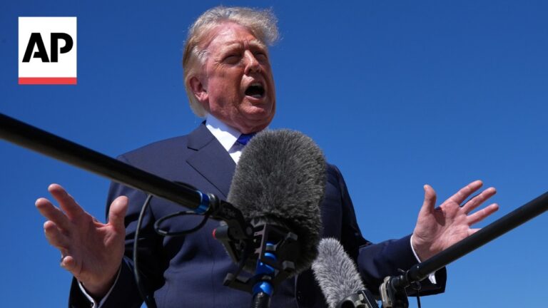 Former U.S. President Donald Trump speaking at a podium with multiple microphones, against a clear blue sky, AP logo visible on the left.