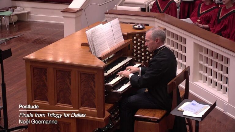 An elderly man in a dark blazer plays a wooden pipe organ console in a church, with a choir in red robes behind a white railing; open music sheets on the stand and papers on a side table. The text overlay reads 'Postlude Finale from Trilogy for Dallas Noël Goemanne'