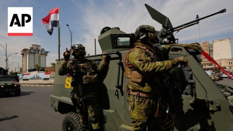 AP logo in top-left corner; soldiers in camouflage on an armored vehicle with a mounted gun in an urban street scene, conveying a military operation.